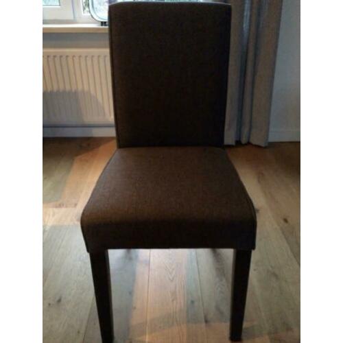 Vier antraciet grijze stoelen.